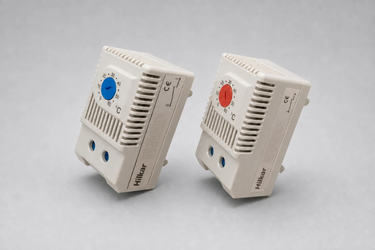 Two DIN rail thermostats with blue and red 0–60 °C setting knobs for anti-condensation heater control